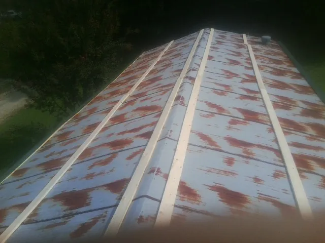 Rusted metal roof panels with new wood purlins before replacement — Storm Damage Roof Repair in Flushing by Roofing Brothers