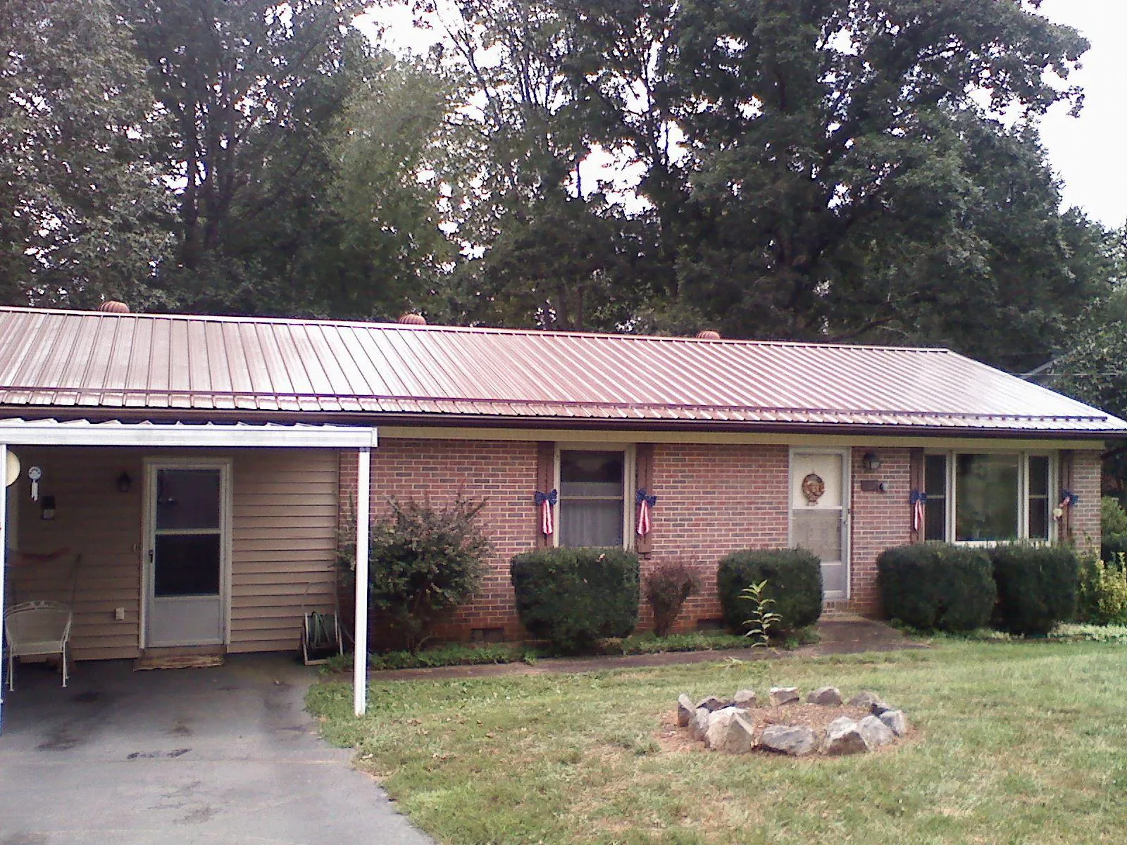 Bronze metal roof and carport on a brick ranch home — Roof Repair work by our crew in Flushing